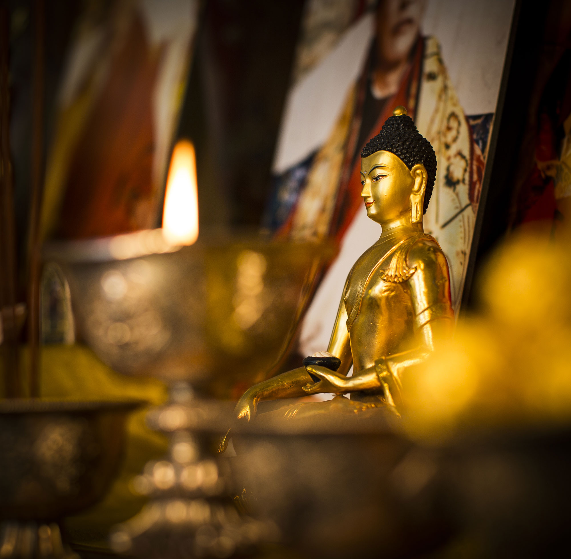 Small statue of the Buddha in candle light